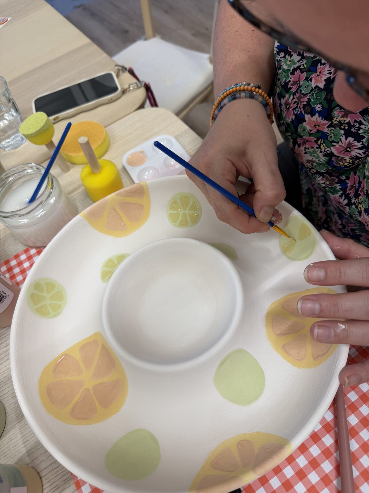 Handen beschilderen een keramieken schaal met citroenen tijdens een workshop keramiek schilderen bij ZoëZo Creatief in Odijk bij Houten
