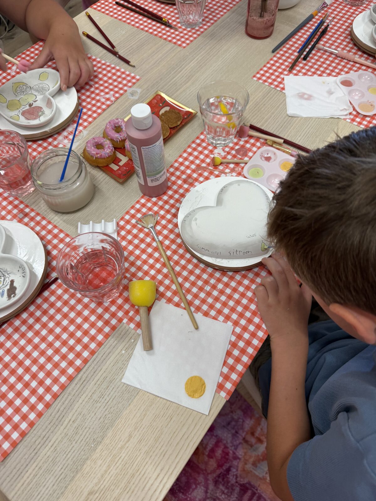 Kind schildert een keramieken hartje tijdens een kinderfeestje in Houten