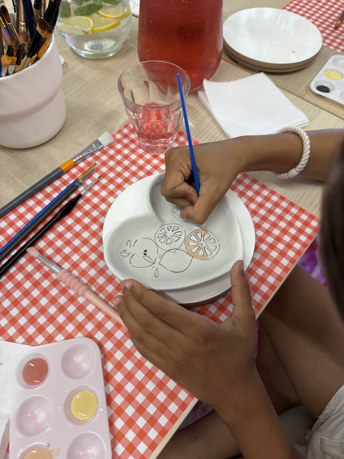 Kinderen beschilderen keramiek aan tafel tijdens een kinderfeestje bij ZoëZo Creatief in Odijk bij Houten