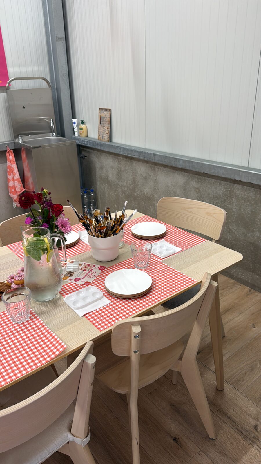 Gedekte werktafel met bloemen en verf in het atelier van ZoëZo Creatief